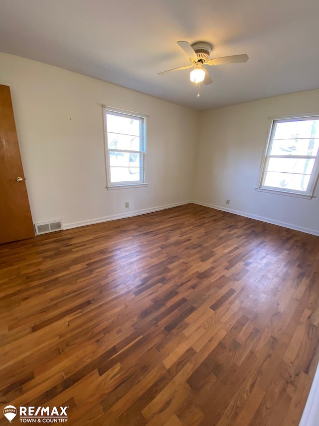 6007 Corunna Rd, Flint, MI 48532 - spare room featuring dark wood-style flooring, a ceiling fan, and baseboards