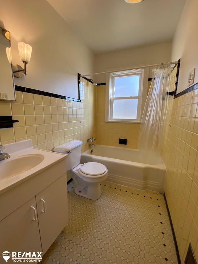 6007 Corunna Rd, Flint, MI 48532 - full bathroom with tile walls, shower / bath combo with shower curtain, vanity, toilet, and wainscoting