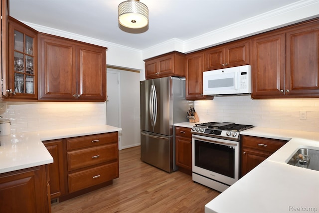 4121 S Fulton Pl, Royal Oak, MI 48073 - kitchen with stainless steel appliances, tasteful backsplash, light countertops, glass insert cabinets, and ornamental molding