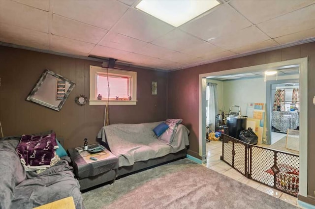 carpeted living area with tile patterned flooring and a paneled ceiling