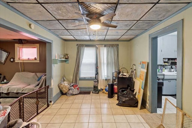 interior space with tile patterned floors, baseboards, a healthy amount of sunlight, and ceiling fan