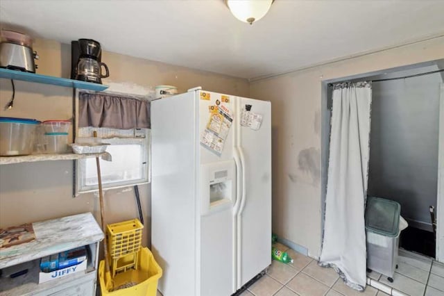 kitchen featuring light tile patterned flooring and white fridge with ice dispenser