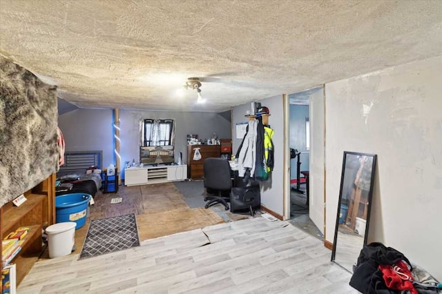 below grade area with a textured ceiling and wood finished floors