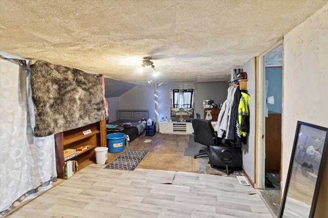 interior space featuring vaulted ceiling, wood finished floors, and a textured ceiling