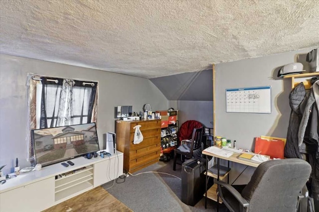 home office featuring carpet floors, vaulted ceiling, and a textured ceiling