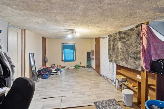 workout area featuring a textured ceiling and wood finished floors