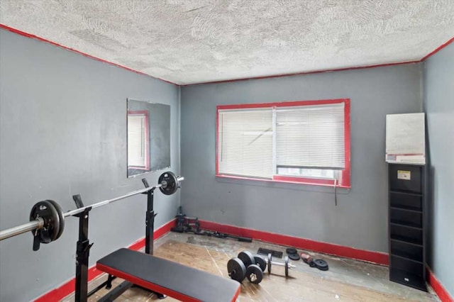 exercise area featuring baseboards and a textured ceiling
