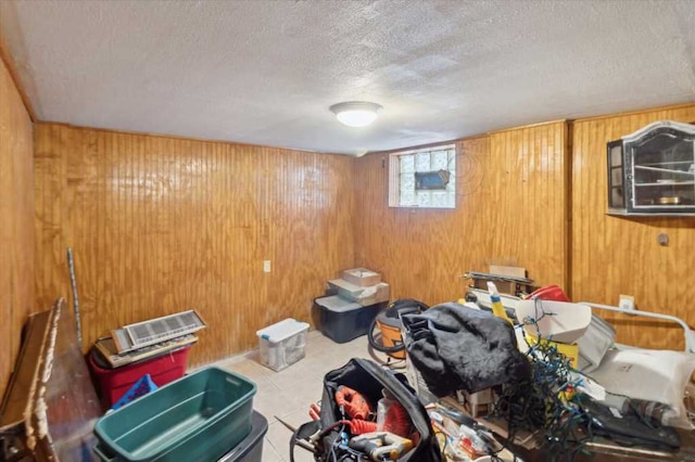 interior space with tile patterned flooring, wood walls, and a textured ceiling