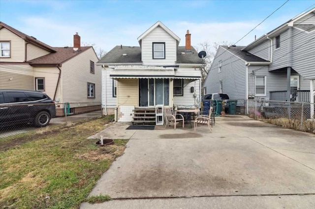 rear view of house with a patio, entry steps, fence, and roof with shingles