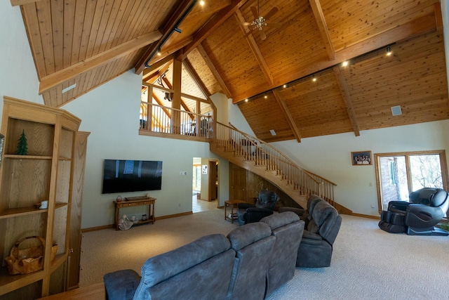 living area featuring carpet flooring, stairs, track lighting, and wooden ceiling