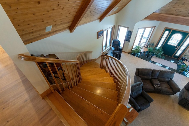 stairway with wood ceiling, high vaulted ceiling, beamed ceiling, and wood finished floors