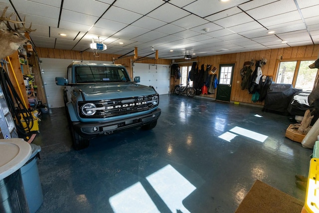 garage with a garage door opener and wooden walls