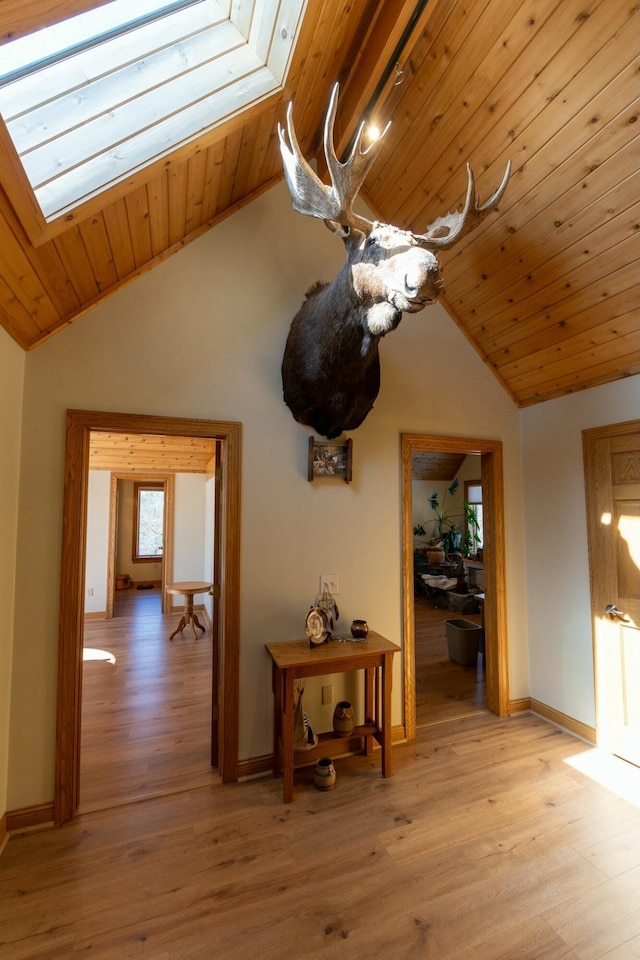 corridor with wooden ceiling, a skylight, and light wood-style floors