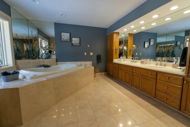 bathroom with a bath, double vanity, a sink, and recessed lighting