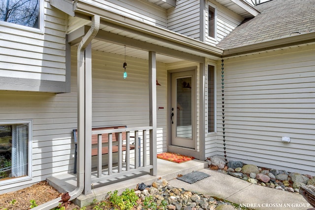 property entrance with covered porch and roof with shingles