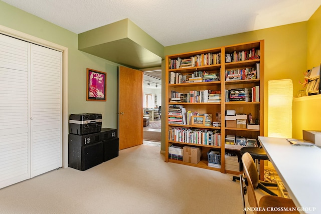 carpeted home office featuring a textured ceiling
