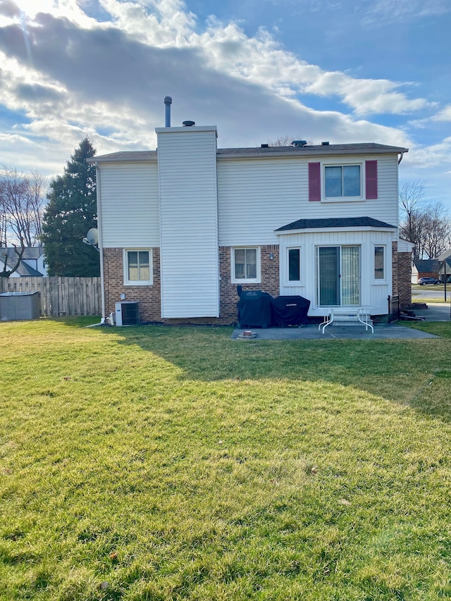 rear view of house featuring central AC unit, a chimney, fence, brick siding, and entry steps