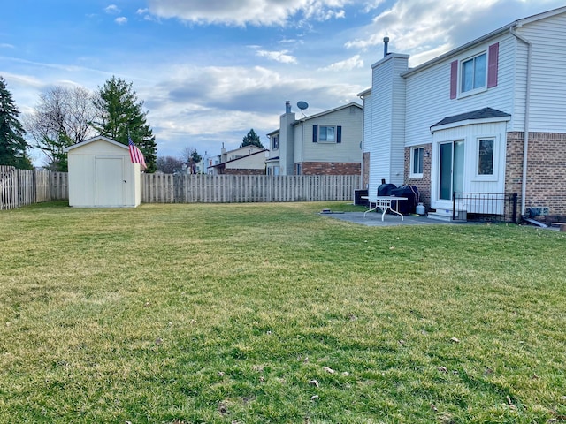 view of yard featuring a fenced backyard, a storage unit, an outdoor structure, and a patio