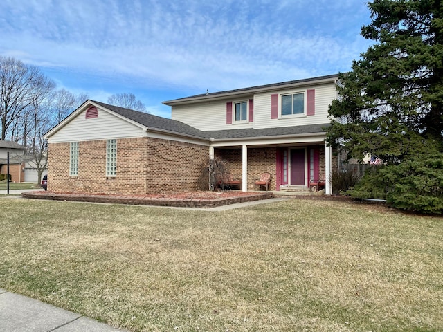 traditional-style house featuring a front lawn and brick siding