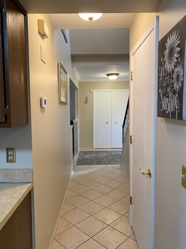 hallway featuring stairway, baseboards, crown molding, and light tile patterned floors