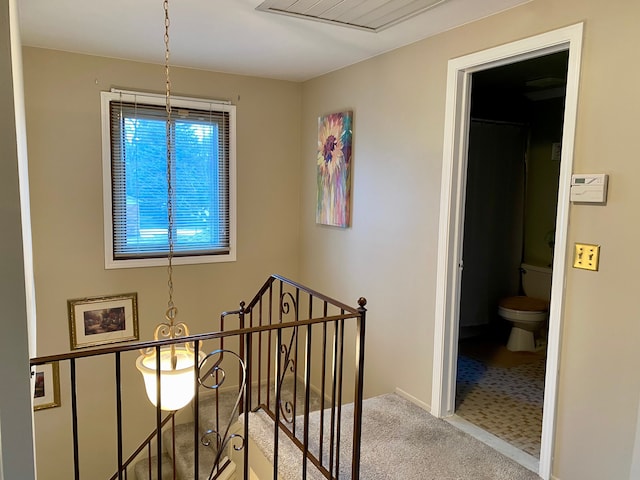 staircase featuring baseboards and carpet