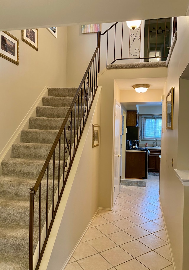 staircase featuring baseboards and tile patterned flooring
