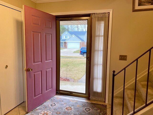 entryway featuring stairway, ornamental molding, and light tile patterned floors