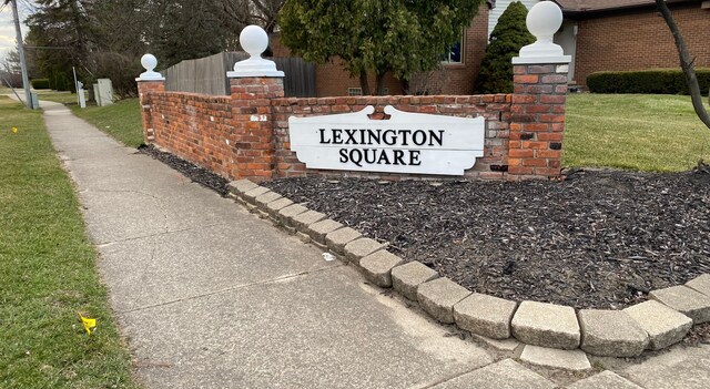 community / neighborhood sign with a yard