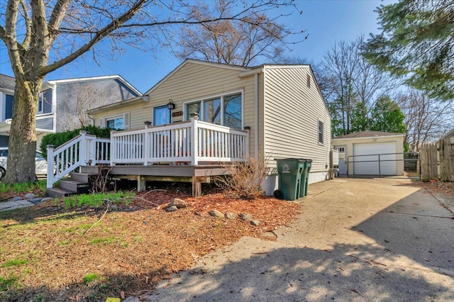 3034 Wolcott St, Ferndale, MI 48220 - view of front facade with concrete driveway, an outbuilding, a garage, a deck, and fence
