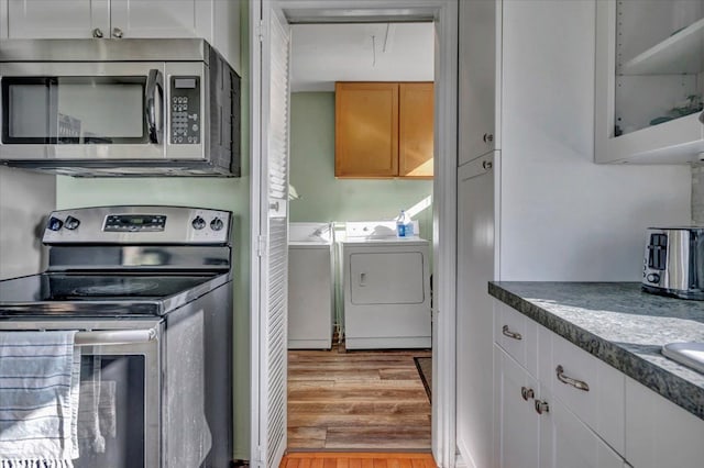 3034 Wolcott St, Ferndale, MI 48220 - kitchen featuring glass insert cabinets, light wood-style flooring, white cabinetry, washing machine and clothes dryer, and stainless steel appliances