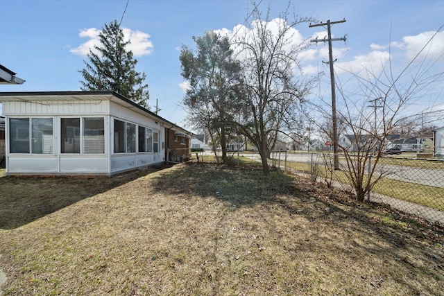 view of yard featuring a sunroom and fence