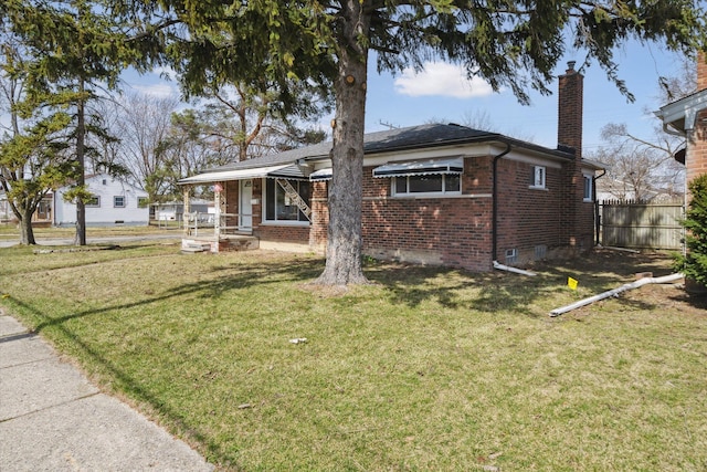 view of front of house with crawl space, fence, a front lawn, brick siding, and a chimney