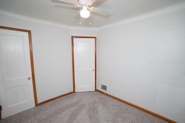 empty room with visible vents, a ceiling fan, carpet flooring, and baseboards