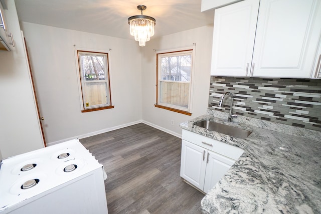 kitchen with dark wood-style floors, an inviting chandelier, a sink, and tasteful backsplash