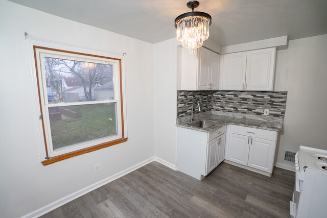 kitchen with dark wood finished floors, white cabinets, backsplash, a sink, and white electric range