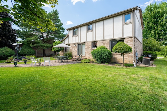 rear view of property featuring a patio, stucco siding, brick siding, central AC unit, and a yard