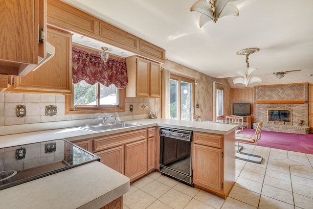 kitchen featuring a peninsula, light tile patterned flooring, open floor plan, black dishwasher, and a sink