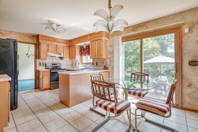 kitchen featuring stainless steel electric range oven, light countertops, light tile patterned floors, freestanding refrigerator, and under cabinet range hood