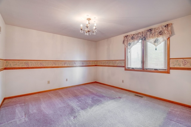 empty room featuring carpet floors, a chandelier, baseboards, and visible vents