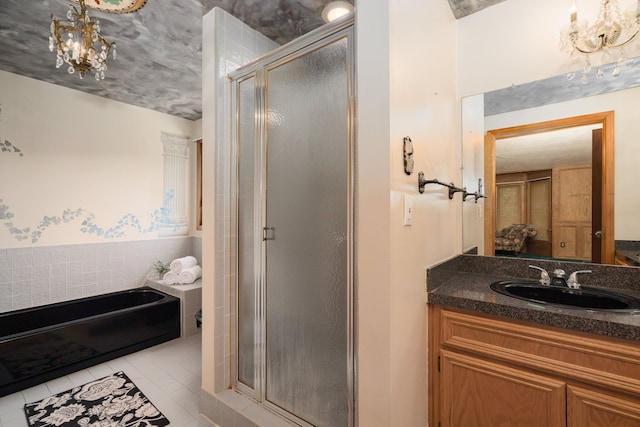 full bathroom featuring vanity, tile patterned flooring, a stall shower, and a chandelier