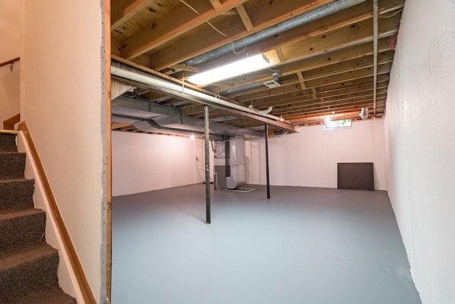 below grade area with heating unit and stairway