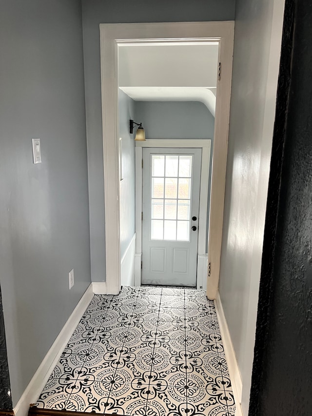 doorway featuring baseboards and tile patterned flooring