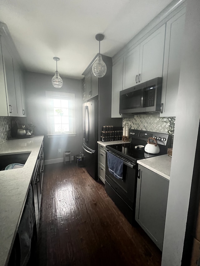kitchen featuring baseboards, decorative backsplash, stainless steel appliances, and dark wood-type flooring