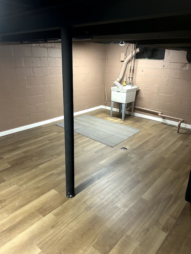 finished basement featuring a sink and wood finished floors