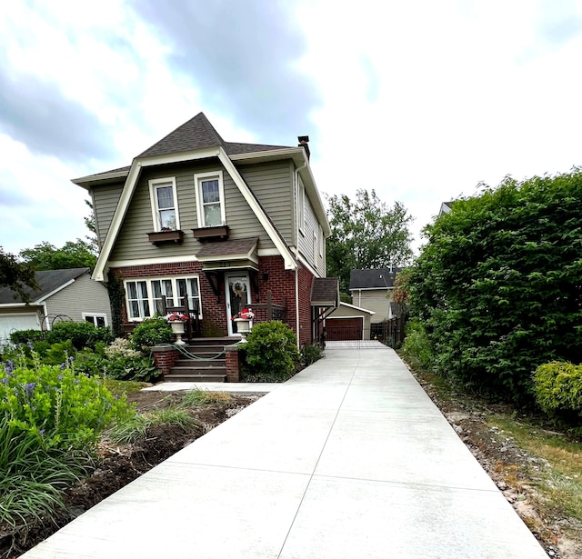 tudor home with brick siding, a shingled roof, and a garage