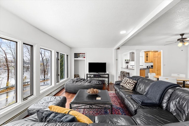 423 Heights Rd, Lake Orion, MI 48362 - living room featuring ceiling fan, wood finished floors, a textured ceiling, a baseboard heating unit, and ornate columns