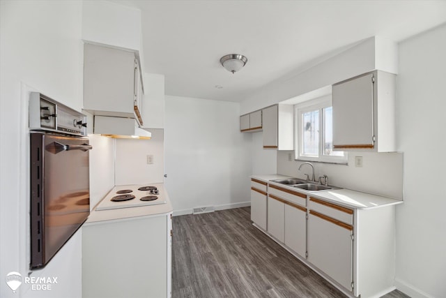 3738 Holly Ave, Flint, MI 48506 - kitchen featuring white electric stovetop, wood finished floors, extractor fan, light countertops, and wall oven