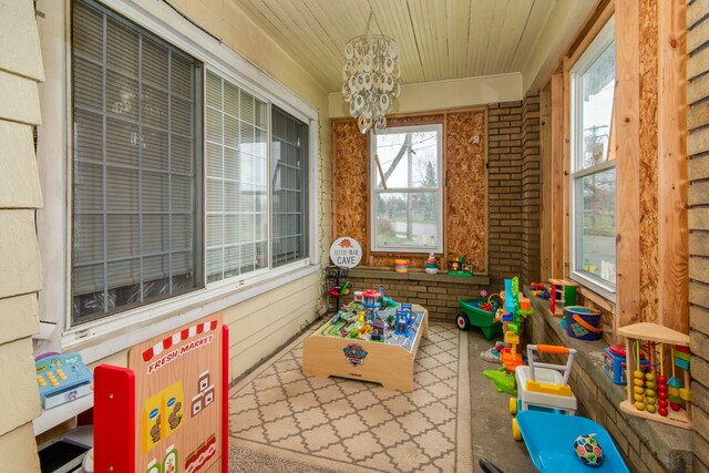 playroom featuring a notable chandelier and wood ceiling
