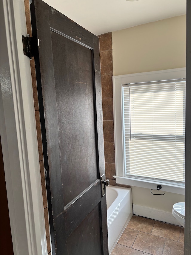 8451 La Salle Blvd, Detroit, MI 48206 - bathroom featuring baseboards, toilet, and a garden tub