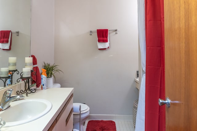 bathroom featuring baseboards, toilet, tile patterned flooring, and vanity